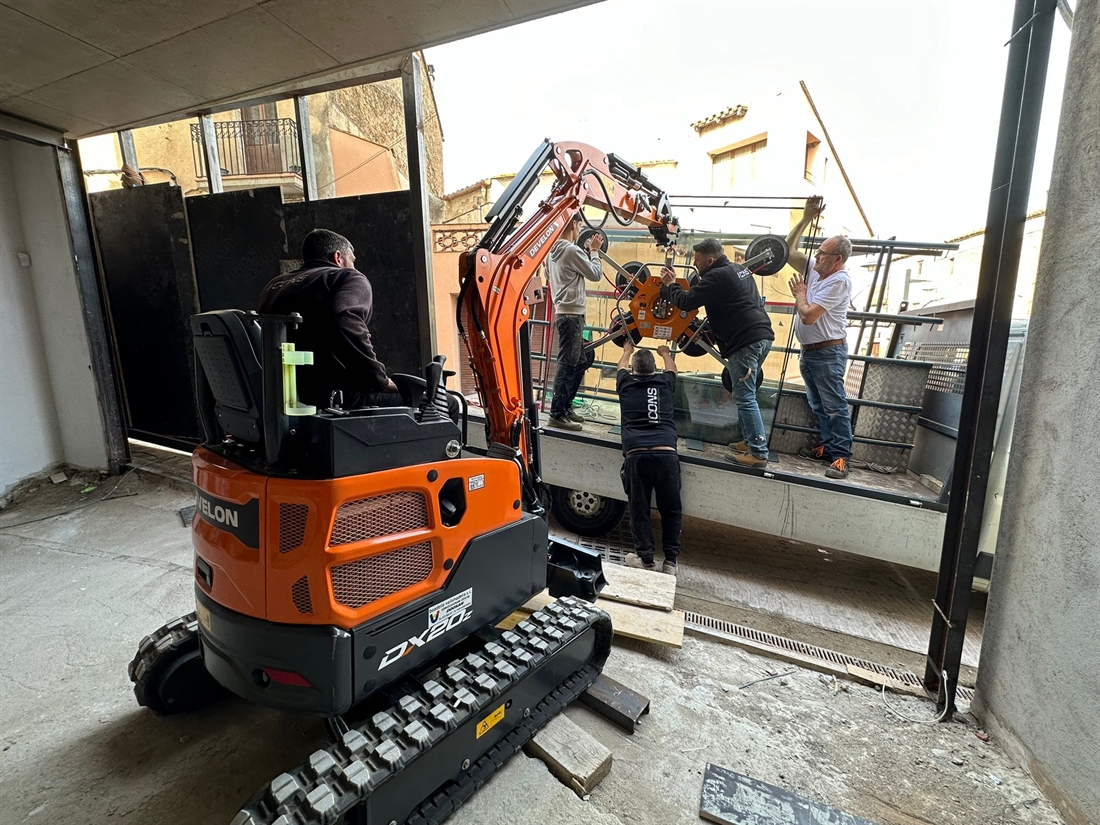 Develon mini-excavator installs glass panes